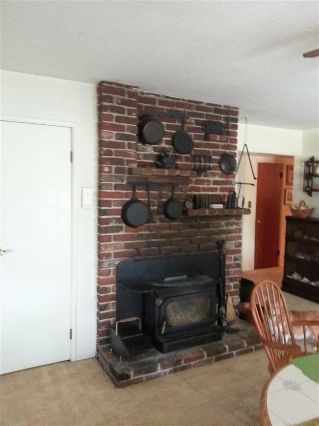 Brick fire place with wood burning stove heats the