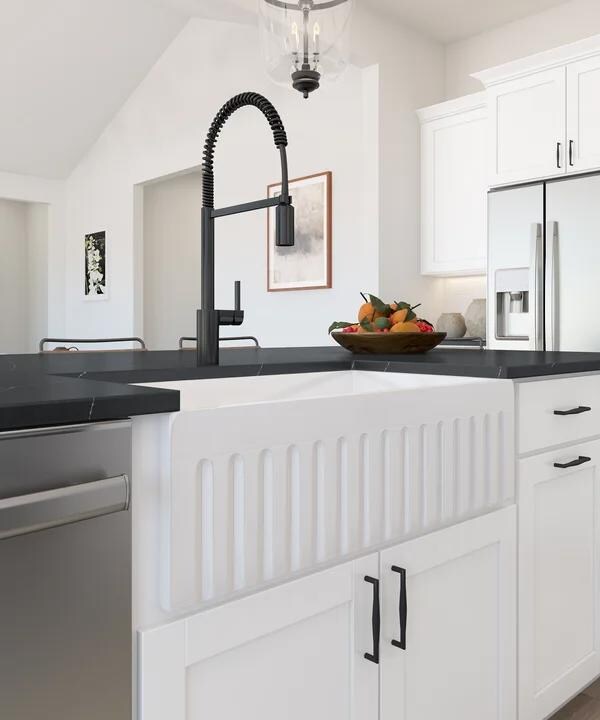 White apron-front farmhouse sink and matte black faucet