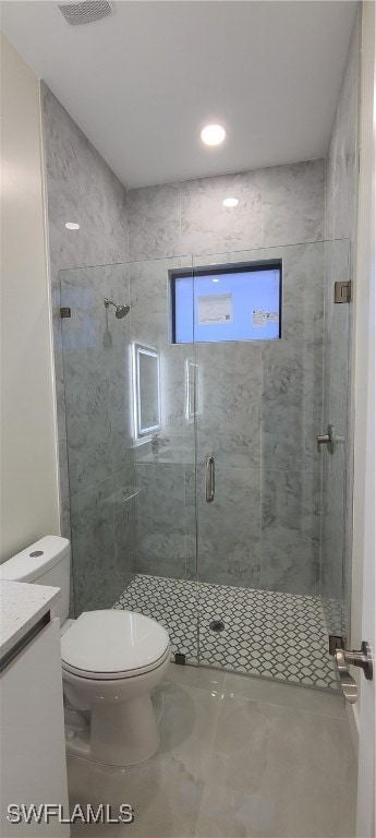 Bathroom with vanity, a shower with door, and toil