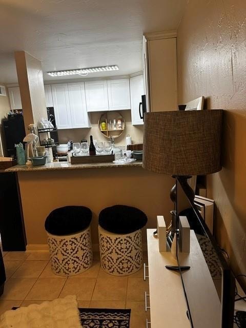 Kitchen with light tile patterned flooring, stone 