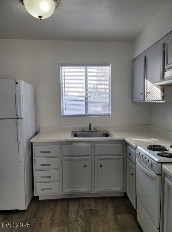 Kitchen with white appliances, a sink, dark wood-t