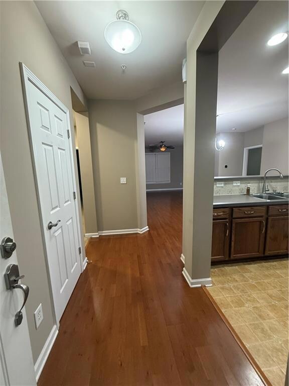 Hall featuring a sink and wood finished floors
