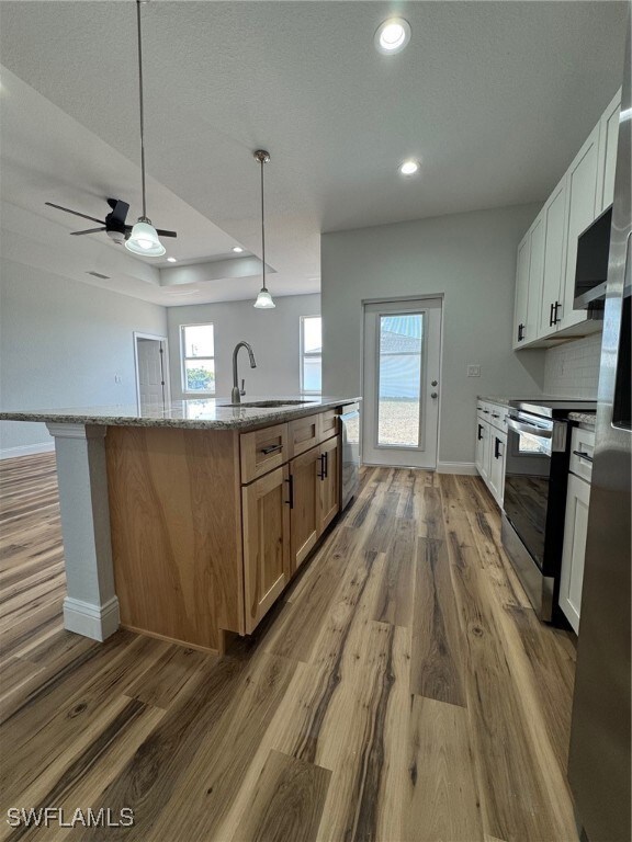 Kitchen with range, a sink, baseboards, and a cent