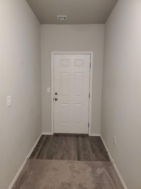 Entryway with visible vents, baseboards, and carpe