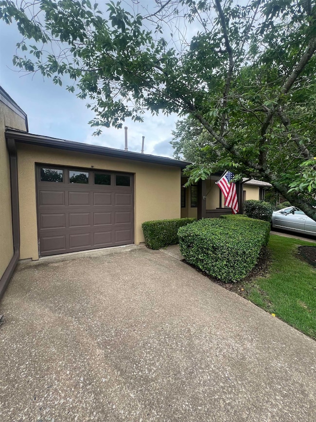 View of front of house featuring concrete driveway, stucco siding, and an attached garage