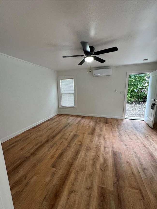 Living room with a textured ceiling, a wall mounte