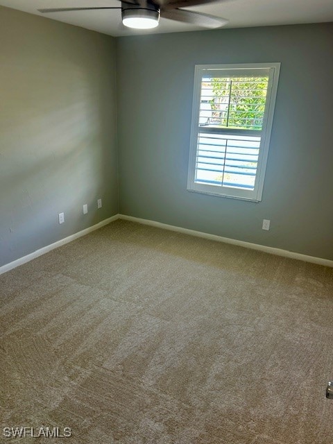Carpeted spare room with baseboards and ceiling fa
