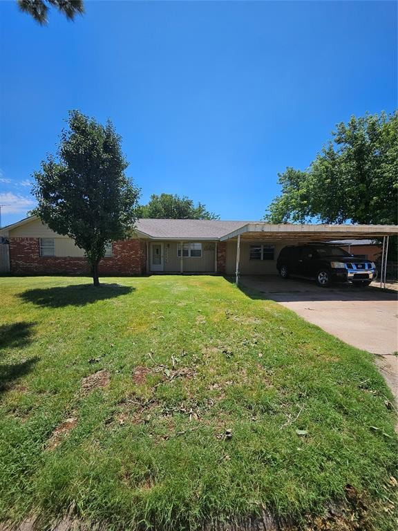 View of front of home featuring driveway, an attached carport, and a front yard