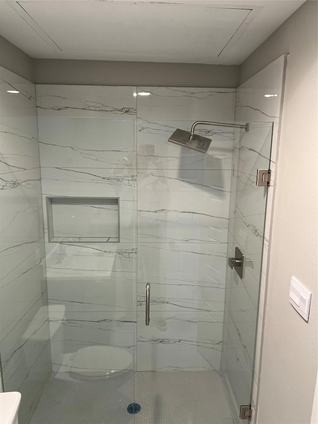Bathroom with a marble finish shower and toilet