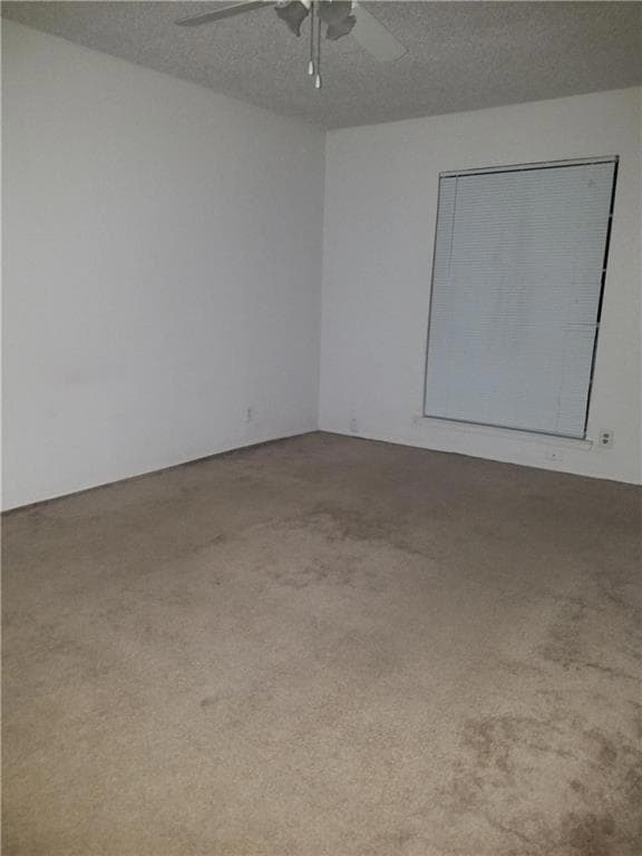Spare room with a ceiling fan and carpet