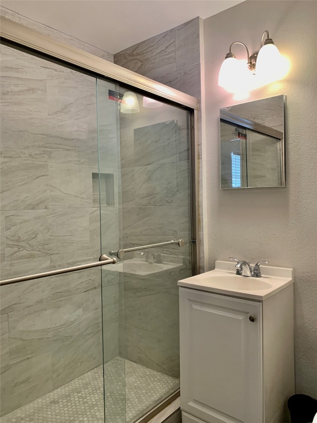 Glass enclosed shower with tile surround