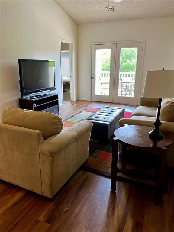 Living area featuring wood finished floors, visibl