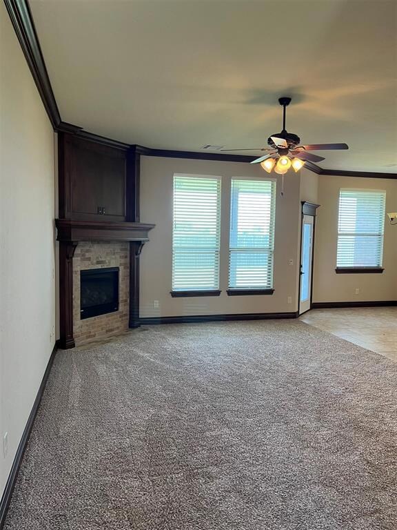 Unfurnished living room featuring crown molding, ceiling fan, and light colored carpet