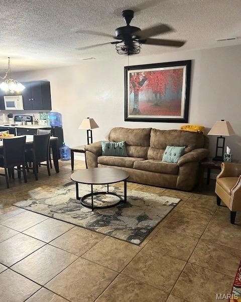 Living room featuring a ceiling fan and a textured ceiling