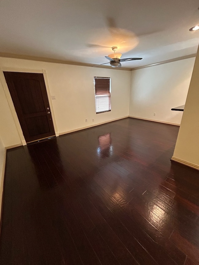 Front living room measures 18x11. Front door in the background. Breakfast bar to the right. Crown molding and baseboards.