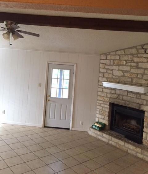 Unfurnished living room featuring beamed ceiling,