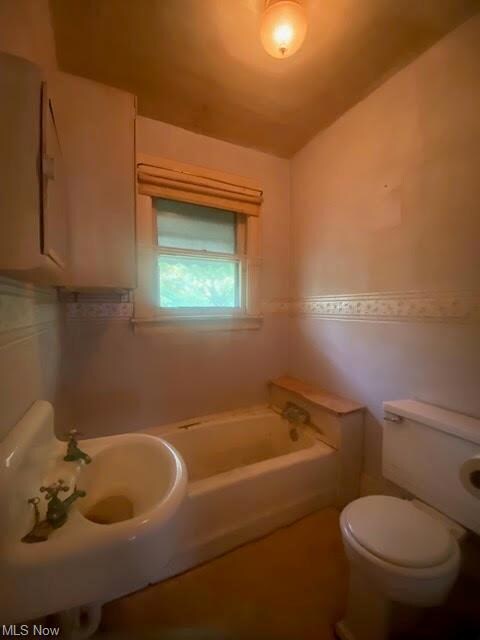 Bathroom featuring sink, a tub, and toilet