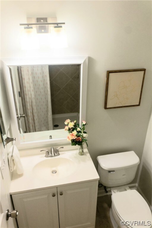 Bathroom with oversized vanity, toilet, and tile f