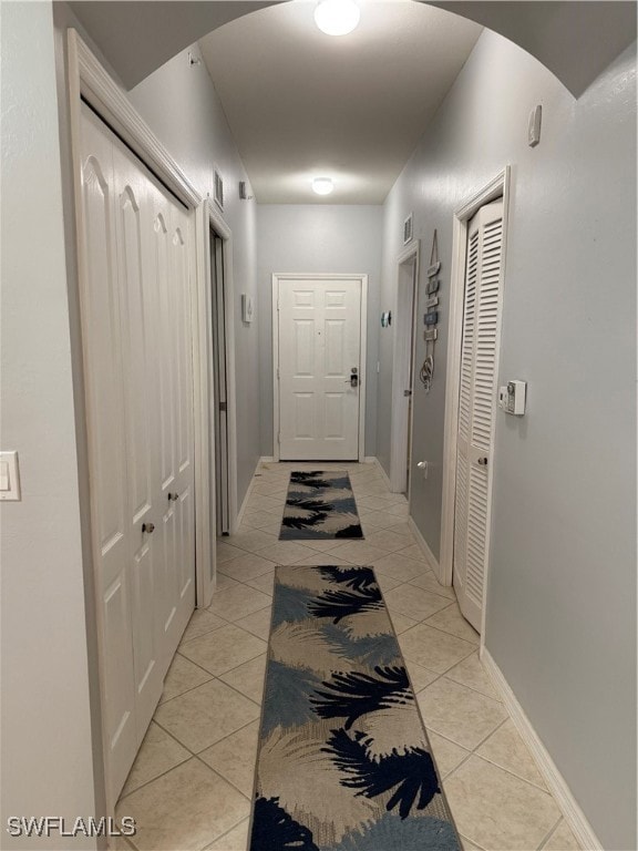 Hall with light tile patterned floors, arched walk