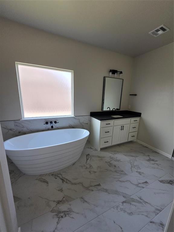 Bathroom with marble finish floor, a freestanding 