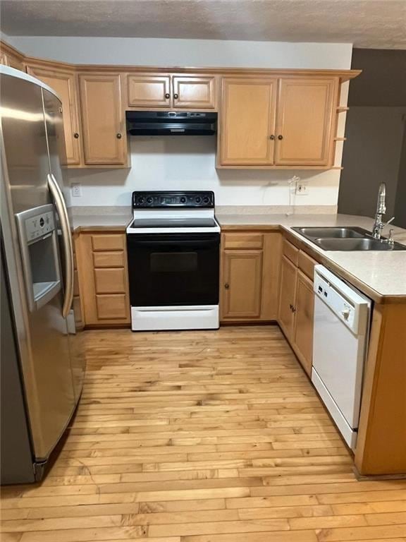Kitchen with electric range, stainless steel fridge, light wood finished floors, light countertops, and a textured ceiling