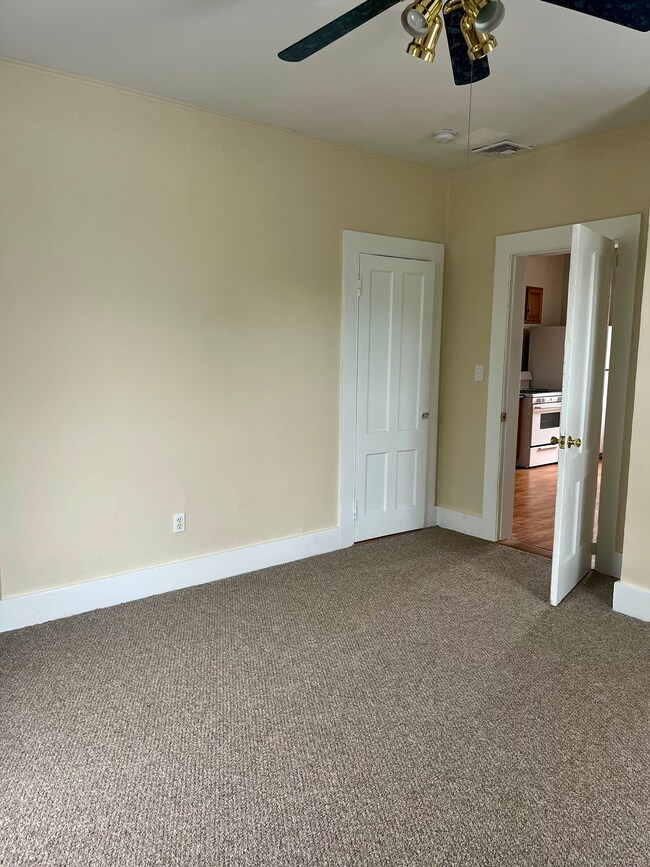 First bedroom off of the kitchen with a fan and 2 closets!