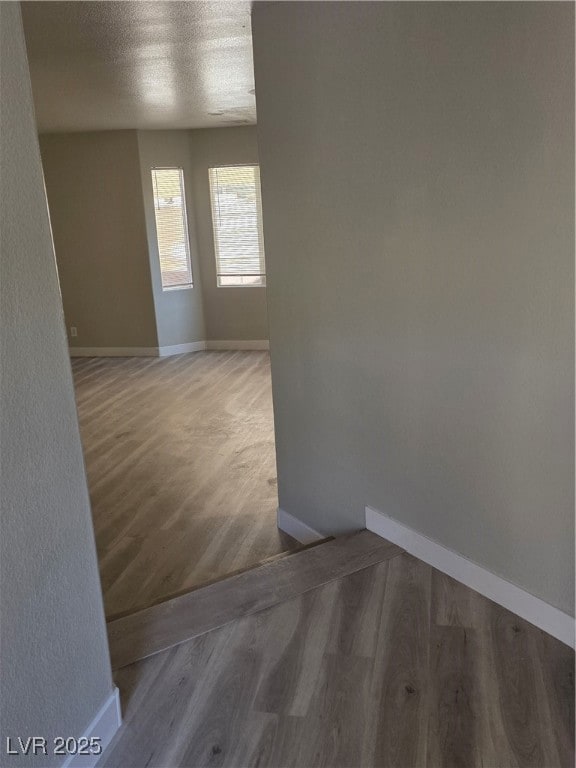 Spare room featuring a textured ceiling and wood finished floors
