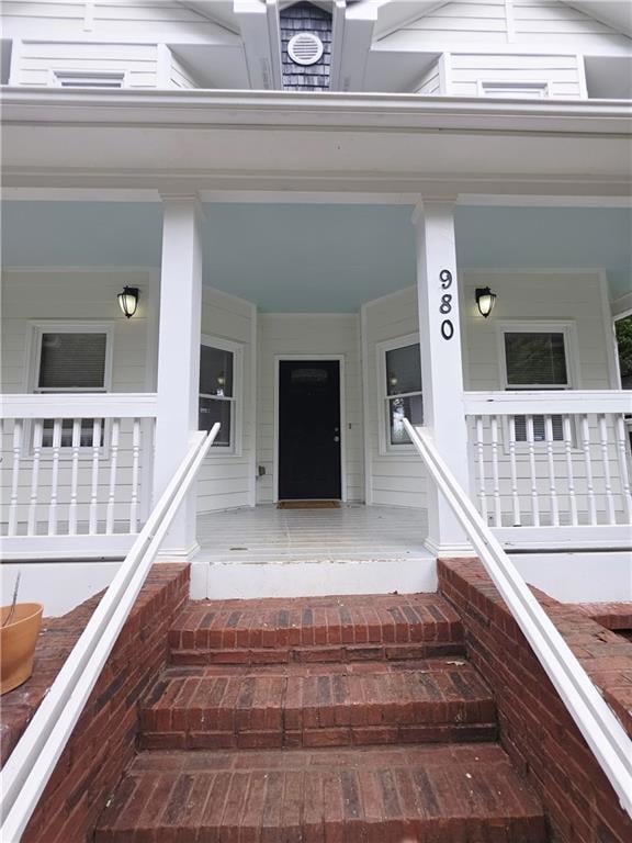 Doorway to property featuring covered porch