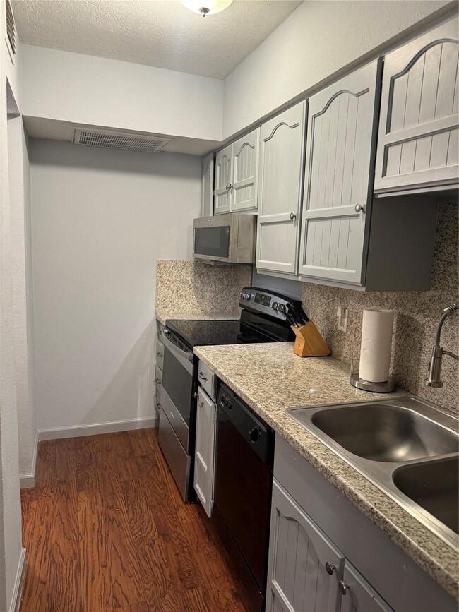 Kitchen featuring dishwashing machine, dark wood-t