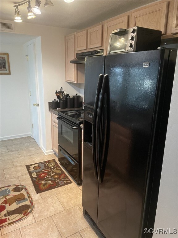 Kitchen with light tile patterned flooring, track lighting, black appliances, and light brown cabinetry