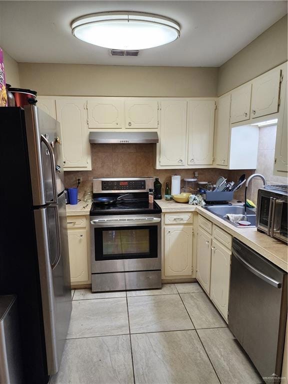 Kitchen with stove, refrigerator, dishwashing machine, ventilation hood, and light countertops