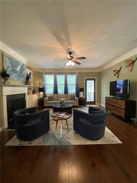 Living area featuring crown molding, built in shel