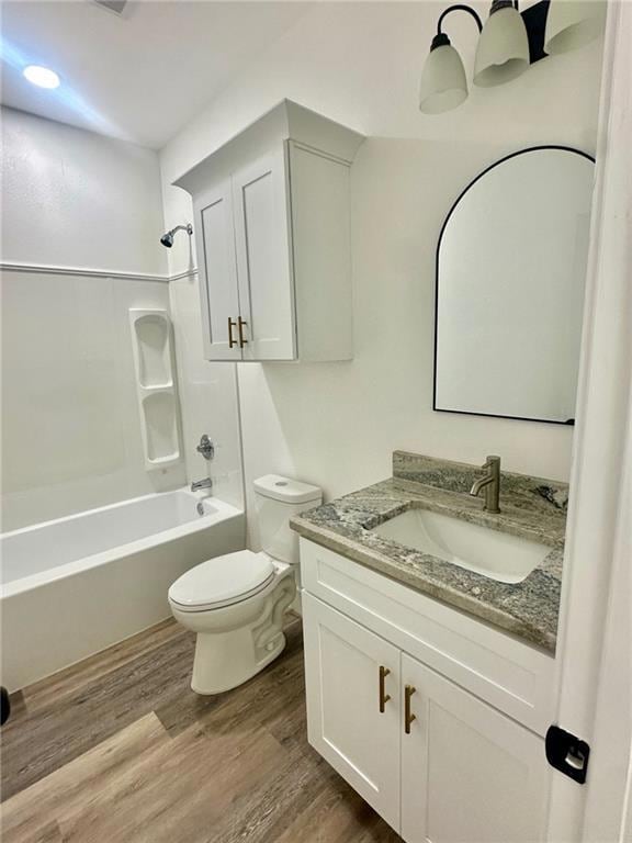 Full bath featuring vanity, bathing tub / shower combination, and dark wood-style flooring