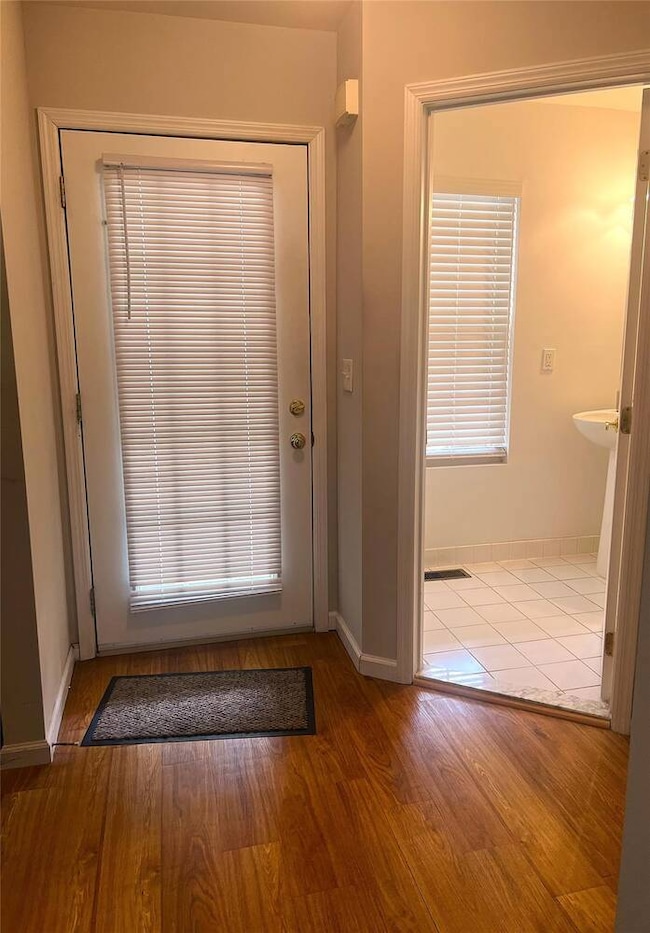 Entryway featuring baseboards and wood finished fl