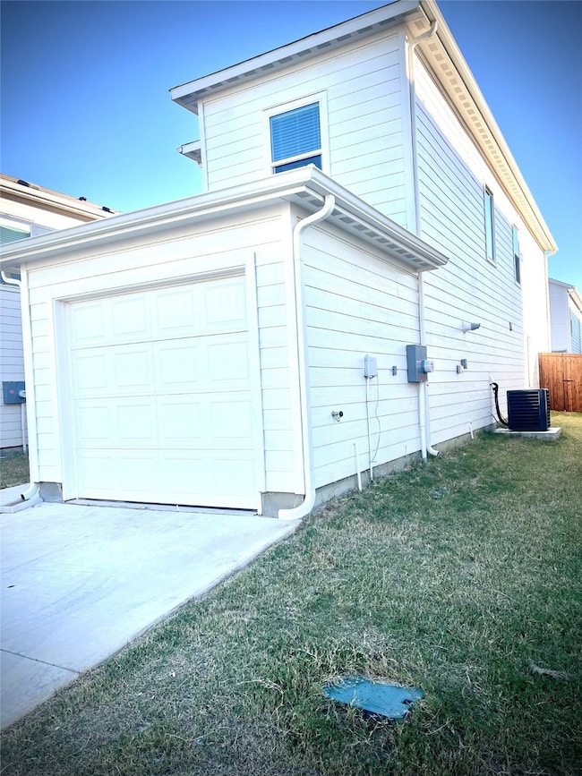 View of side of home with a garage and driveway