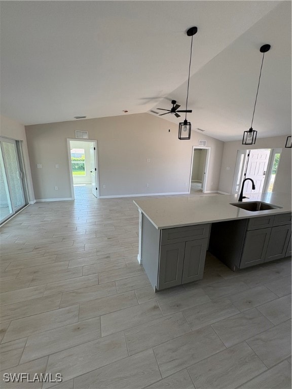 Kitchen with open floor plan, gray cabinetry, vaul
