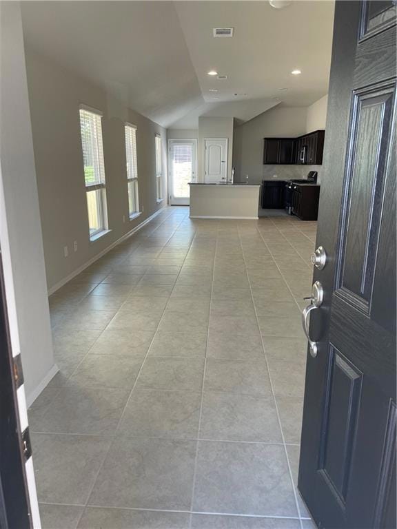 Foyer featuring lofted ceiling, light tile patter