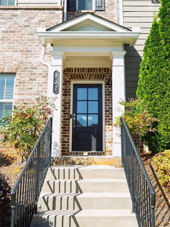 View of exterior entry featuring brick siding