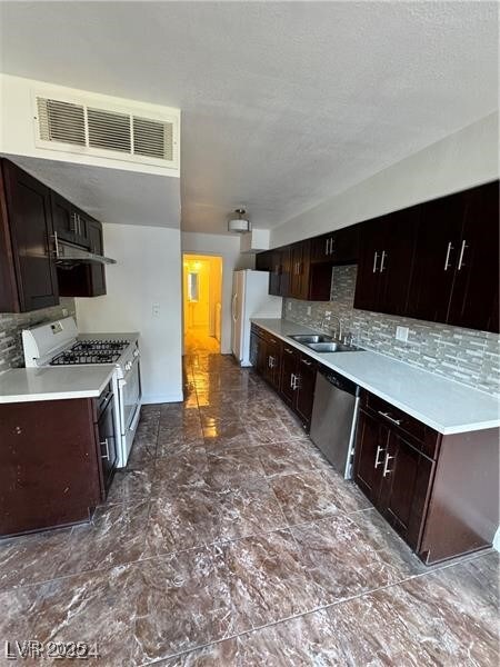 Kitchen featuring white appliances, a sink, decora