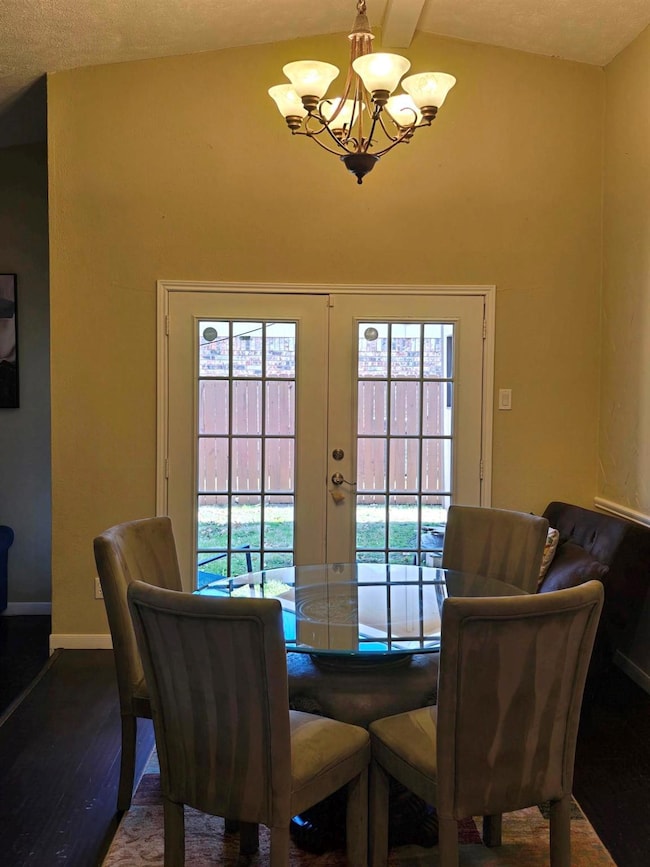 Dining area with dark wood-type flooring, a chande