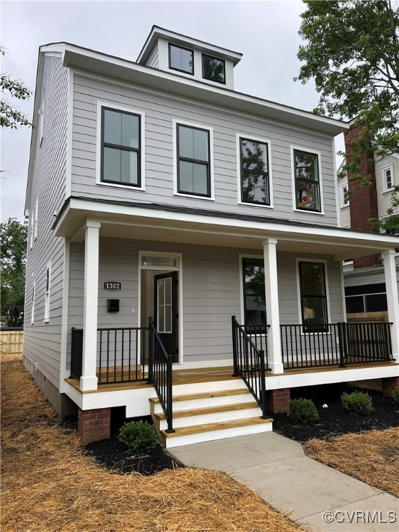 American foursquare style home featuring a porch