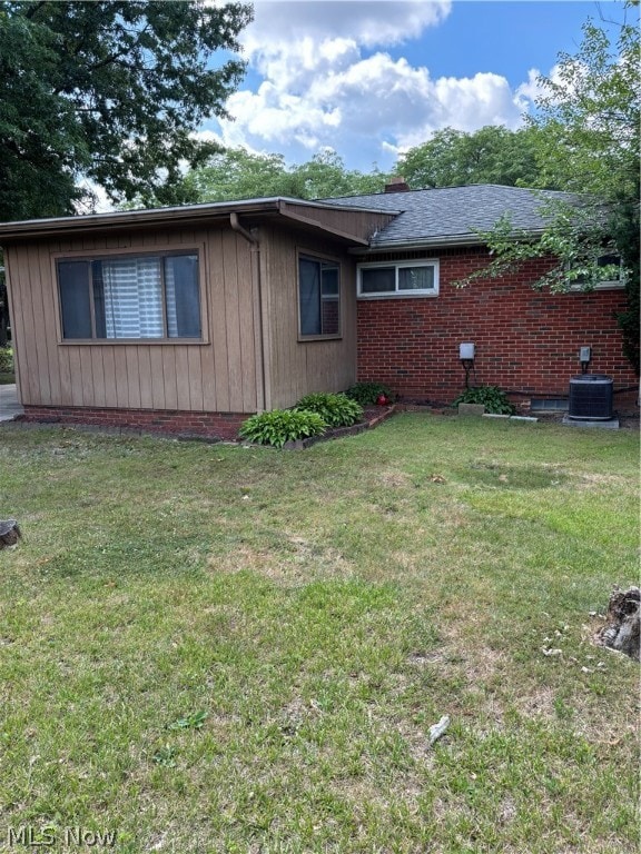 View of home's exterior featuring central air condition unit and a lawn