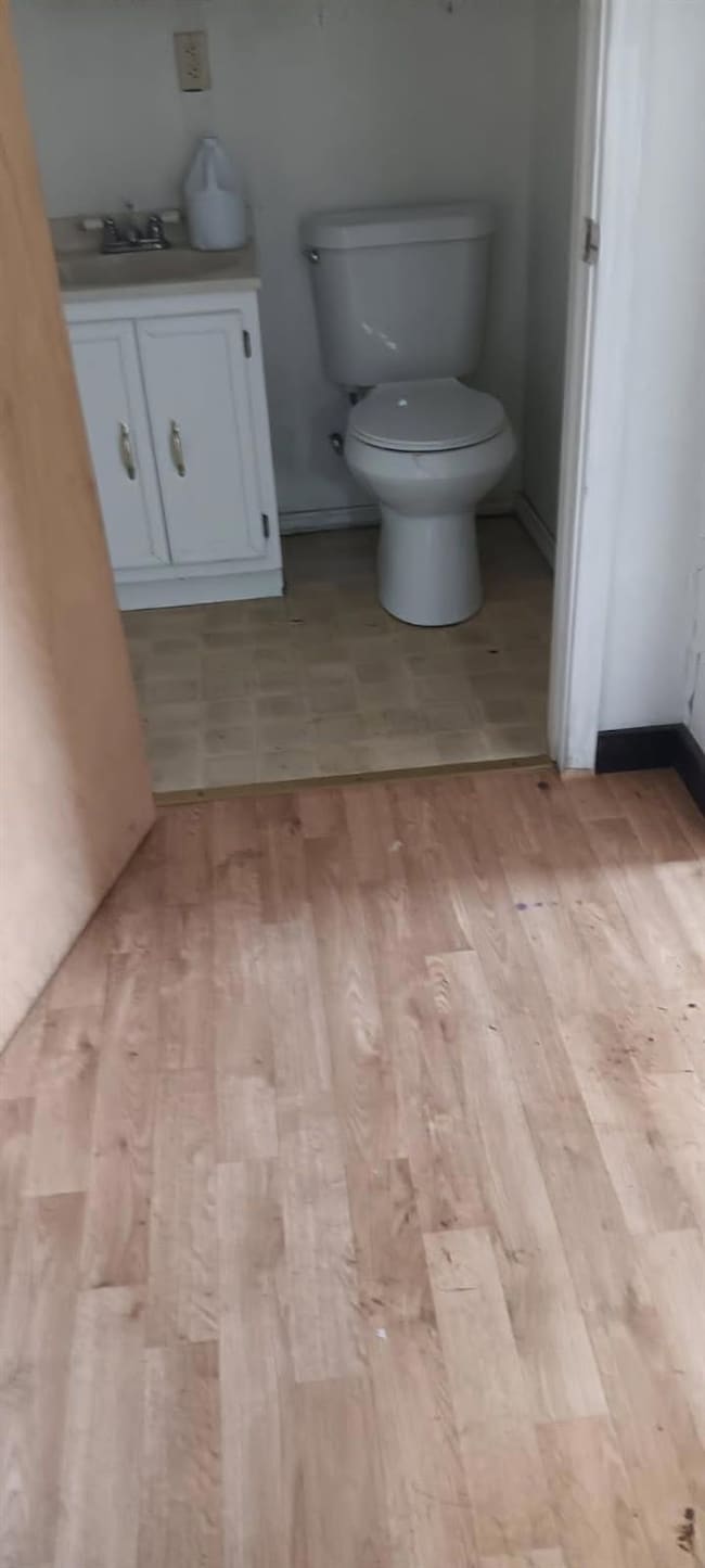 Bathroom featuring toilet, wood finished floors, a