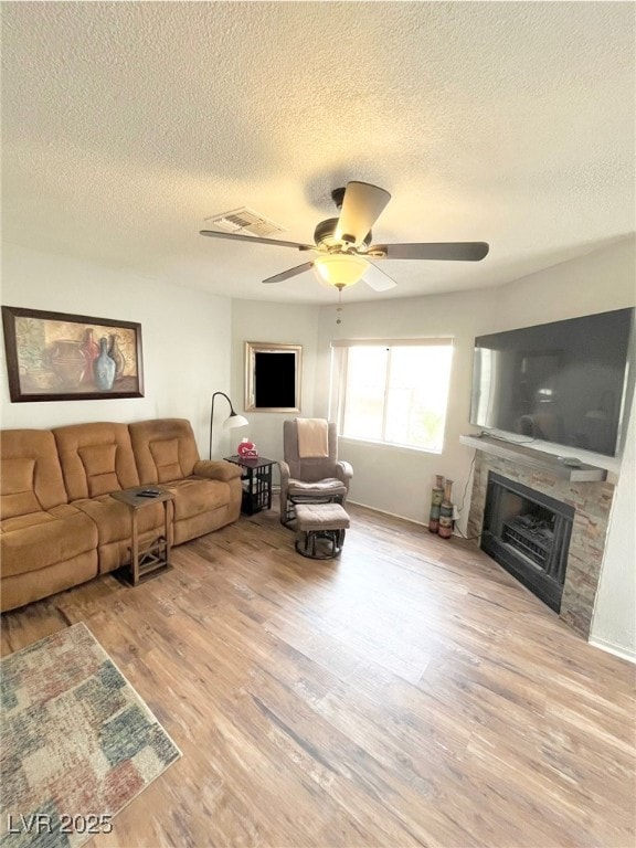 Living room featuring ceiling fan, a fireplace, a