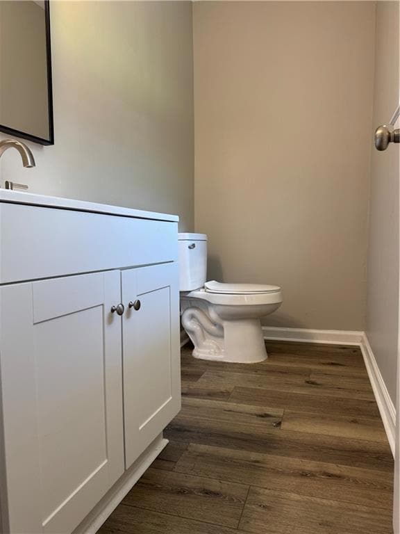 Half bath featuring vanity and dark wood finished floors