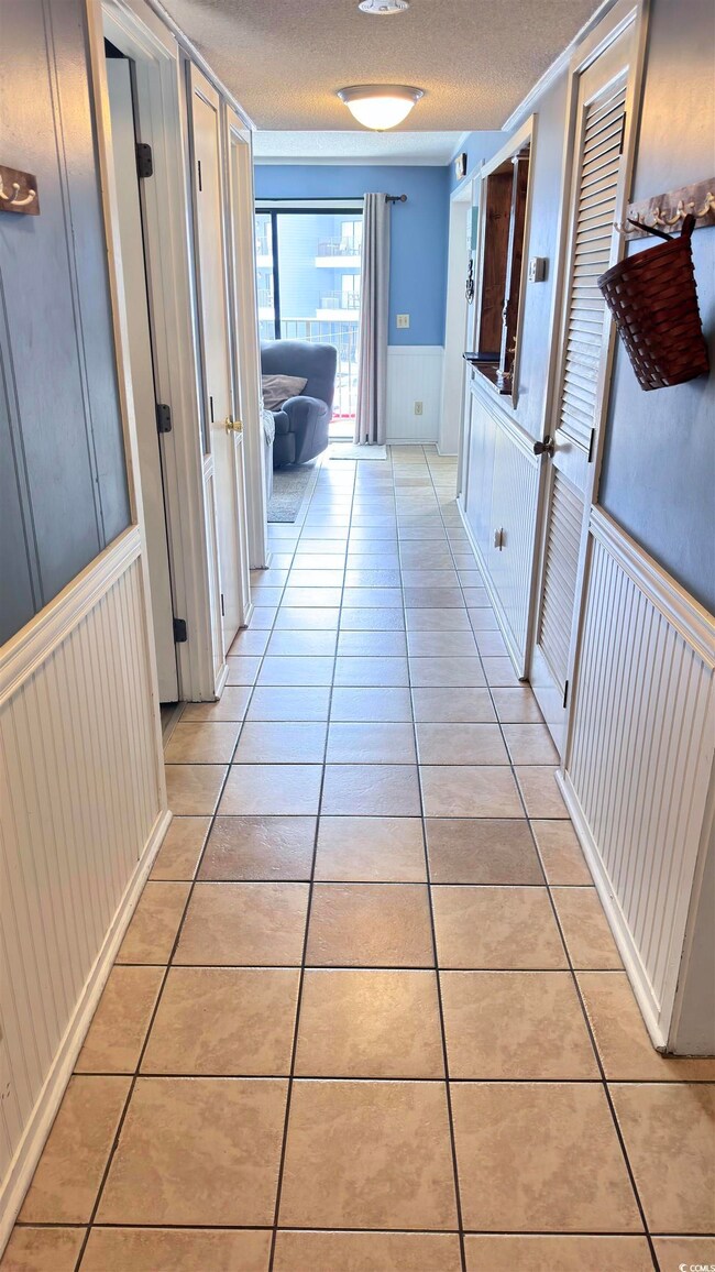 Corridor with a textured ceiling and light tile pa