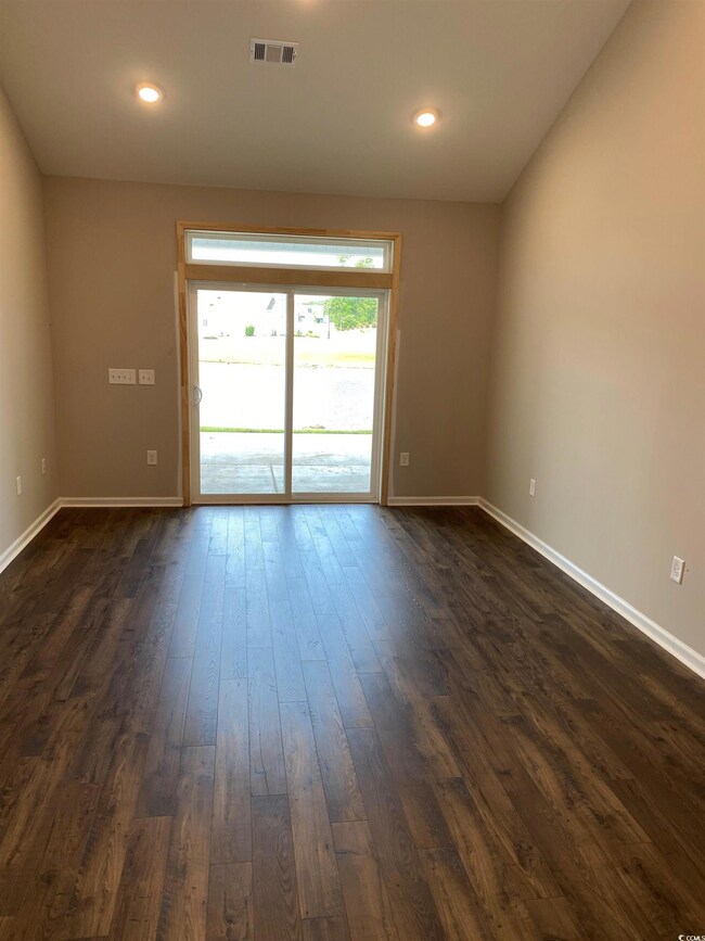 Empty room featuring dark wood-type flooring