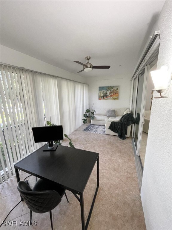 Living area featuring ceiling fan and light tile p
