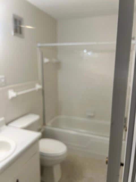 Bathroom with vanity, washtub / shower combination, and toilet