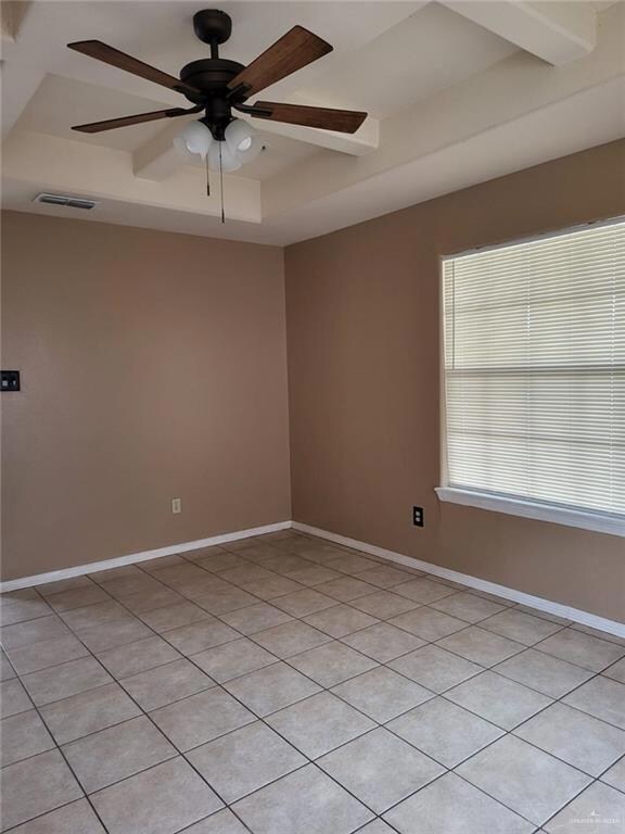 Unfurnished room with light tile patterned floors, a ceiling fan, and a raised ceiling